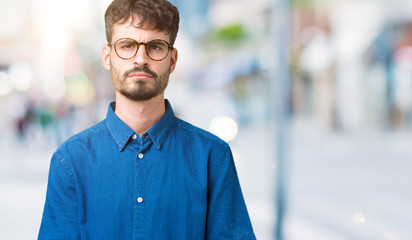 Sticker - Young handsome man wearing glasses over isolated background skeptic and nervous, frowning upset because of problem. Negative person.