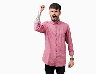 Sticker - Young handsome man wearing pink shirt over isolated background angry and mad raising fist frustrated and furious while shouting with anger. Rage and aggressive concept.