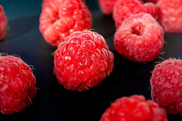 Wall Mural - Fresh organic raspberries background closeup. Fresh raspberries on black background