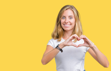 Beautiful young woman wearing casual white t-shirt over isolated background smiling in love showing heart symbol and shape with hands. Romantic concept.