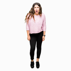 Sticker - Young beautiful woman wearing pink sweater afraid and shocked with surprise expression, fear and excited face.