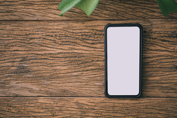 Aufkleber - Smart phone on wooden background with copy space. top view.