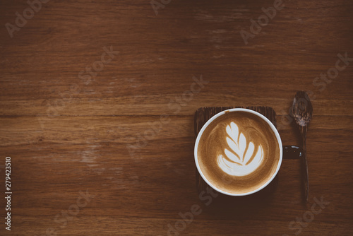 Photographie Cup of coffee latte with beautiful latte art on wood table background,topview
