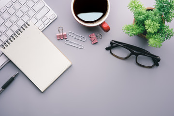 Aufkleber - Flat lay, top view office table desk. Workspace with keyboard, office supplies, pencil, green leaf, and coffee cup on gray background.