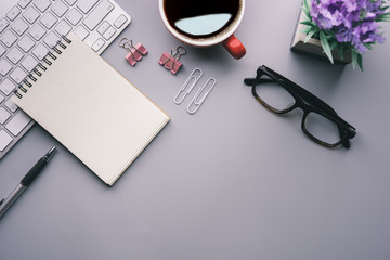 Aufkleber - Flat lay, top view office table desk. Workspace with keyboard, office supplies, pencil, green leaf, and coffee cup on gray background.