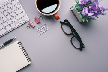 Aufkleber - Flat lay, top view office table desk. Workspace with keyboard, office supplies, pencil, green leaf, and coffee cup on gray background.