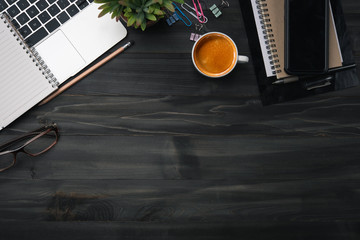 Aufkleber - Modern dark wood office desk table with laptop, smartphone and other supplies with cup of coffee. Blank notebook page for input the text in the middle. Top view, flat lay.