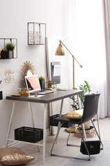 Poster - modern workplace with laptop and golden decor on desk near wall. stylish interior design