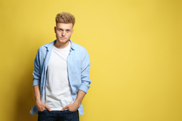 Poster - Young man wearing blank t-shirt on yellow background. Mockup for design