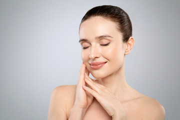 Poster - Portrait of beautiful young woman with perfect skin on grey background. Spa treatment