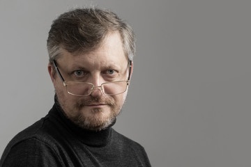 mature man with beard on gray background