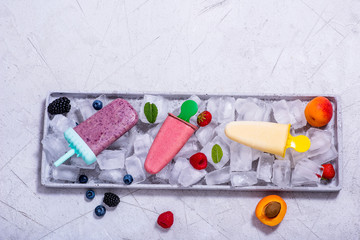 Wall Mural - Popsicles ice cream with fruits and berries on copy space background, summer dessert, natural homemade sweets