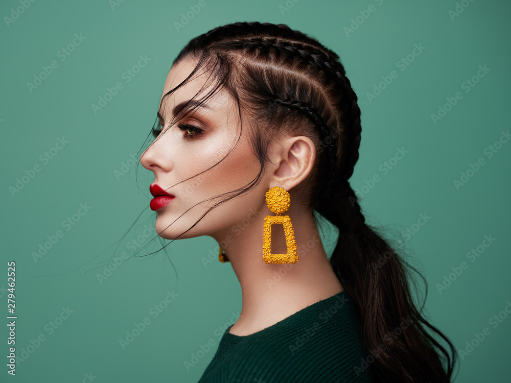 Brunette girl with perfect makeup. Beautiful model woman with curly hairstyle. Care and beauty hair products. Lady with braided hair. Model with jewelry. Turquoise background - obrazy, fototapety, plakaty 