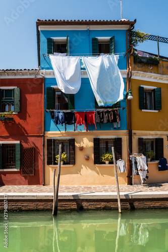 Cuadros en Lienzo Laundry dries on the facades of colorful houses with reflection in canal, Burano