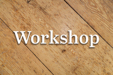Wall Mural - `workshop` white text on a wooden home background.