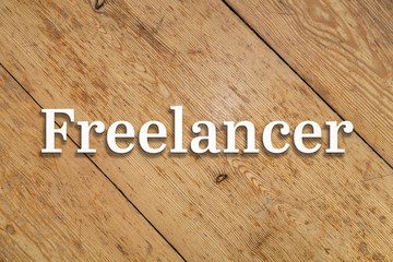 Wall Mural - `freelancer` white text on a wooden background