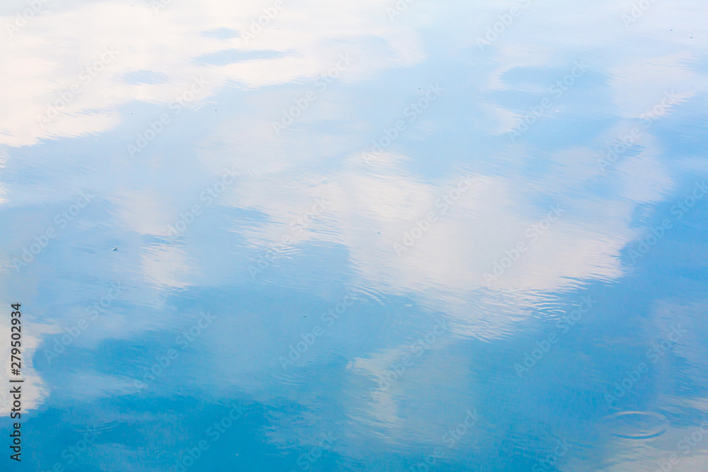 Blue sky and white cloud reflect on the water in a bright day look like ...