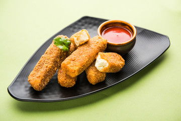 Wall Mural - Kurkuri paneer fingers or pakora/pakoda snacks also known as Crispy Cottage Cheese Bars, served with tomato ketchup as a starter. selective focus