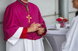 a priest in a purple mantle with a cigarette in his hand