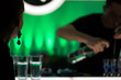 Silhouette of a girl on the background of the bartender preparing cocktails
