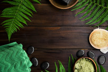 Green Spa Top View Setting With Fern Leaves On Wooden Background With Copy Space, Massage Stones, Green Towel, Clay Powder