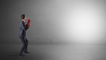 Canvas Print - Businessman fighting with boxing gloves in an empty space