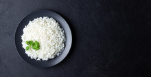 Steamed Rice On Black Plate. Black Stone Background. Top View With Copy Space.