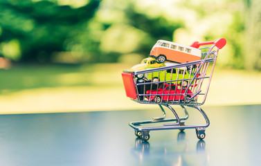 A miniature shopping cart full of cars.