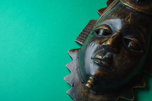 Wooden African Mask On A Green Background, Side View