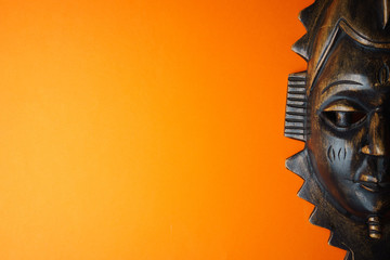 wooden african mask on orange background