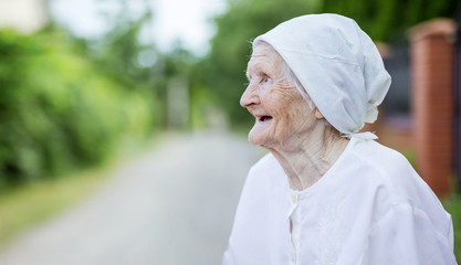 Wall Mural - Happy senior woman looking up outdoors