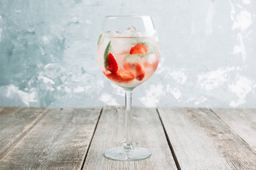 Wall Mural - Martini royale cocktail in wine glass with basil leaves and strawberry. Selective focus. Shallow depth of field.