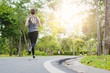 © ibravery - young fitness woman running at the park in morning.