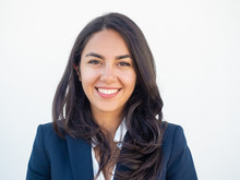 Happy Successful Businesswoman Smiling At Camera Over White Studio Background. Closeup Of Beautiful Black Haired Young Latin Woman Wearing Formal Jacket And Smiling. Business Portrait Concept