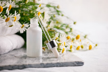 Composition With Skin Care Products In Zero Waste Package And Chamomile Flowers On Marble Plate, Concept Of Flowers And Organic Cosmetic. Essential Camomile Oil