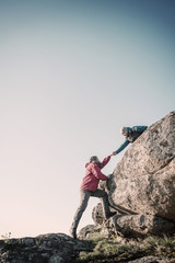 two mans help each other hiking