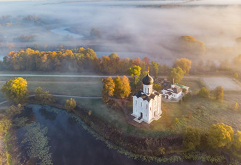 Wall Mural - Church of the Intercession of the Holy Virgin on the Nerl River in morning fog, Russia. Top view