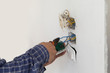 © krsprs - Electrician working at plug socket. Repair concept.