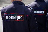 Fototapeta  - Russian police officers during a patrol on a city street. View from the back