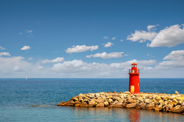 Poster - Mediterranean seascape with an old red lighthouse on a rocky breakwater pier in a sunny summer day with blue cloudy sky, Porto Maurizio, Imperia, Liguria, Italy