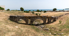 The Paloma Aqueduct With The Atlantic Ocean In The Background Located At The Ancient Roman City Baelo Claudia In Bolonia, Spain Near Gibraltar.