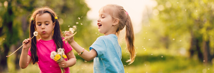 Wall Mural - Two happy little sisters on the field with dandelions