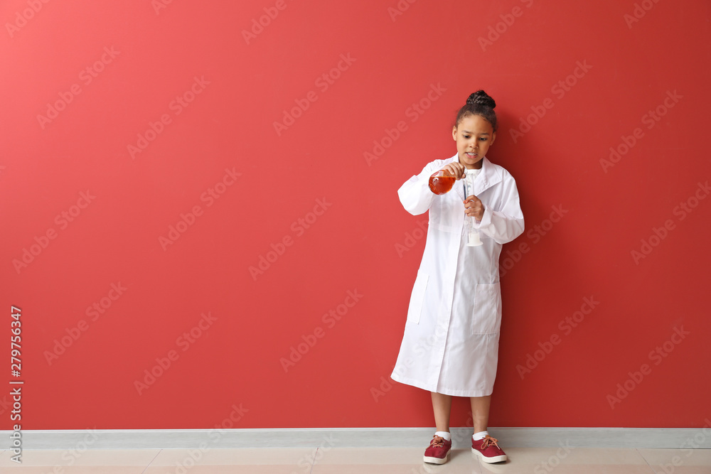 Little African-American scientist near color wall