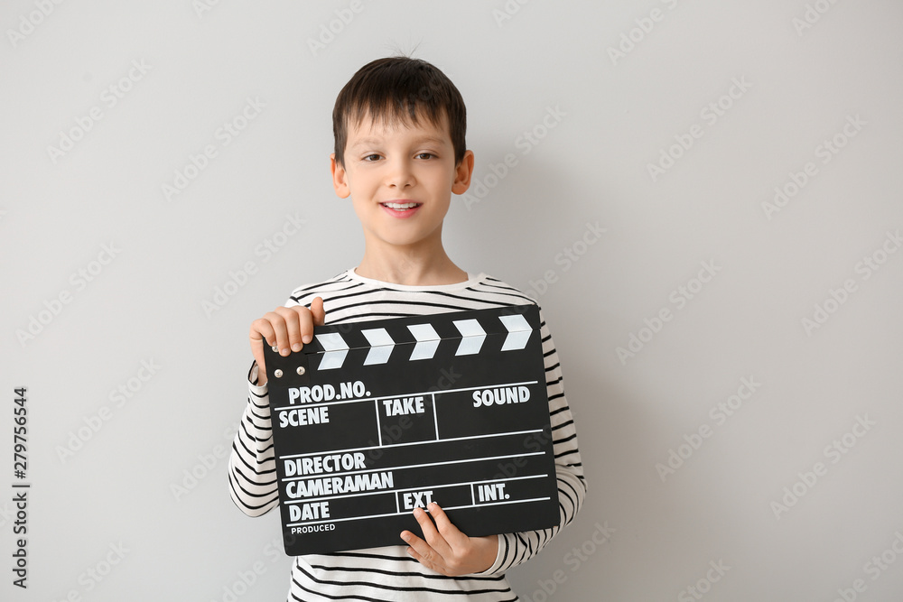 Little boy with clapperboard on white background