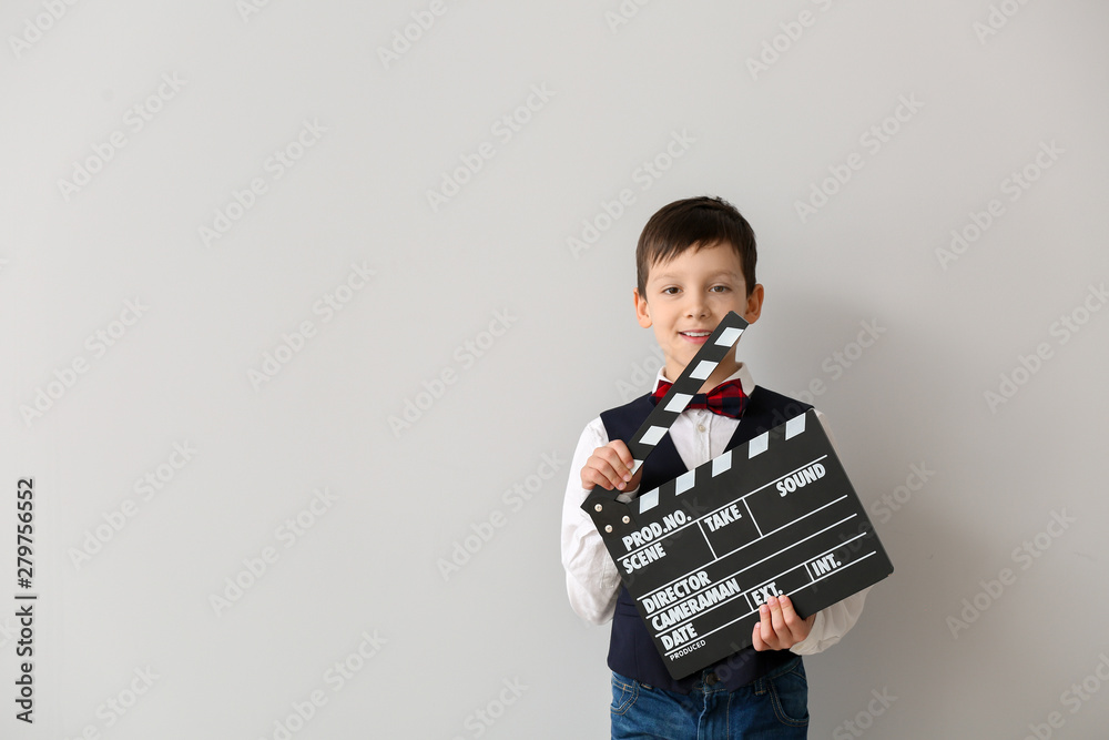 Little boy with clapperboard on white background