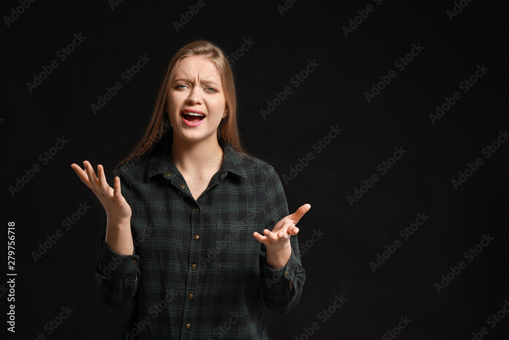 Stressed young woman on dark background