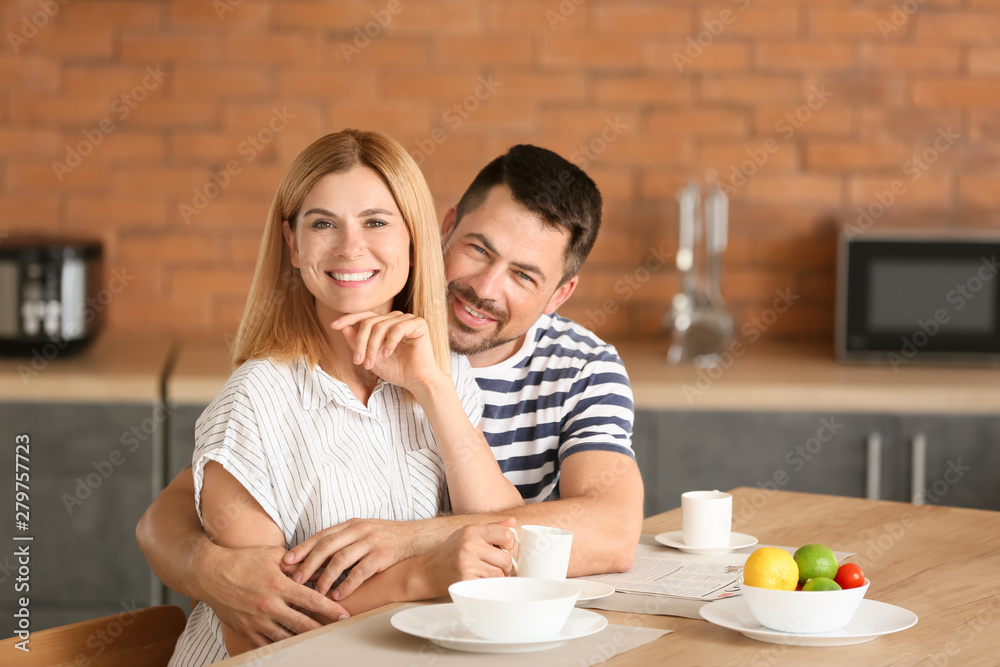 Happy couple having breakfast in kitchen