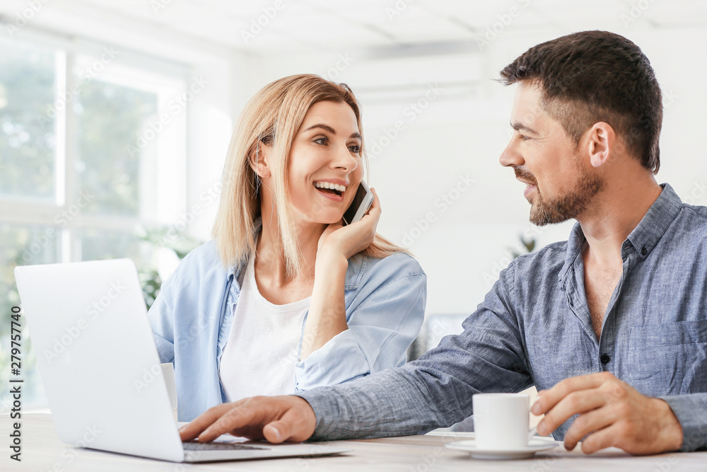 Happy couple in love using laptop at home
