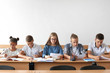 © Pixel-Shot - Pupils passing school test in classroom