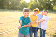 © Pixel-Shot - Group of children pulling rope at summer camp